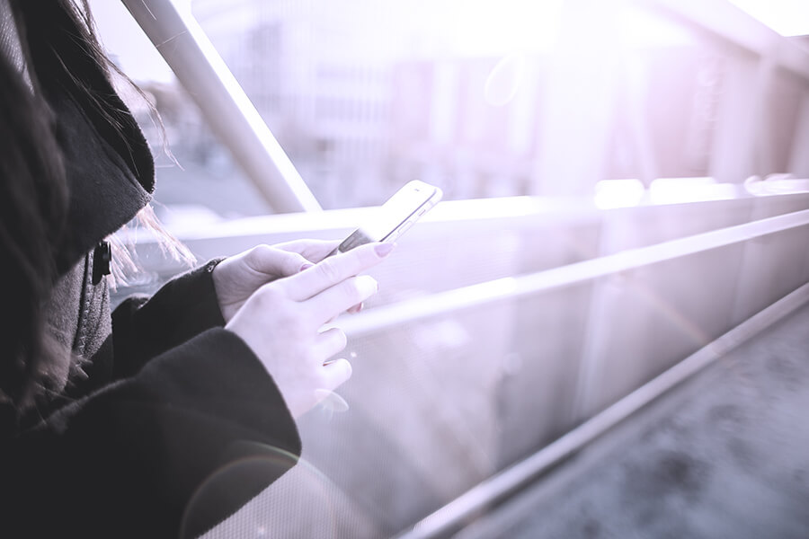 Woman with a mobile phone on a bridge